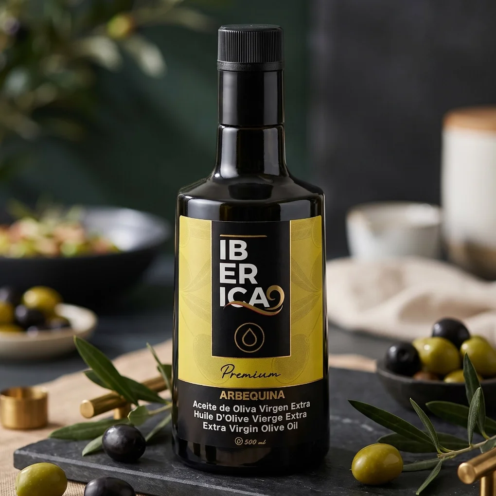 Botella de aceite de oliva virgen extra premium Iberica9 Arbequina de 500 ml sobre una mesa con ambiente mediterráneo.