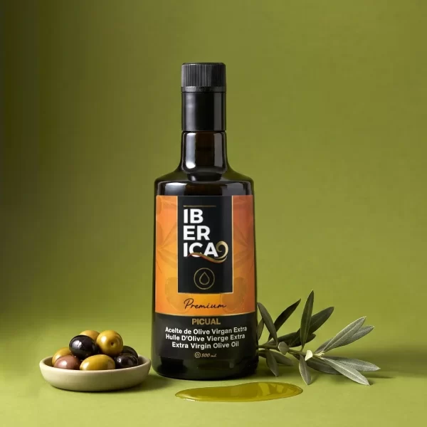 Botella de aceite de oliva virgen extra Picual Iberica9 de 500 ml sobre fondo verde, acompañada de aceitunas.